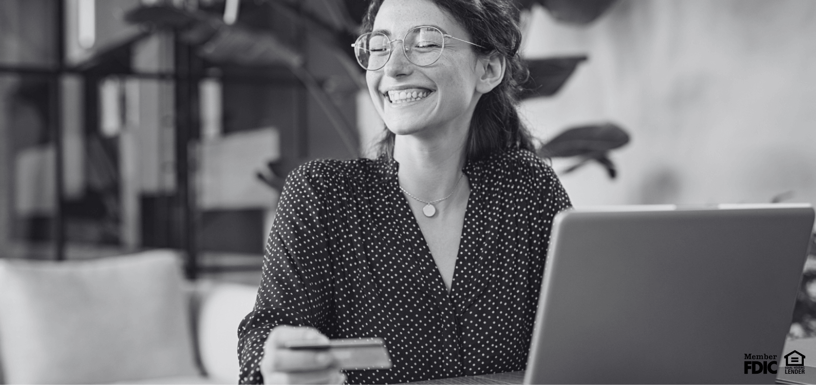 A young woman smiles while checking her online banking account for her checking account