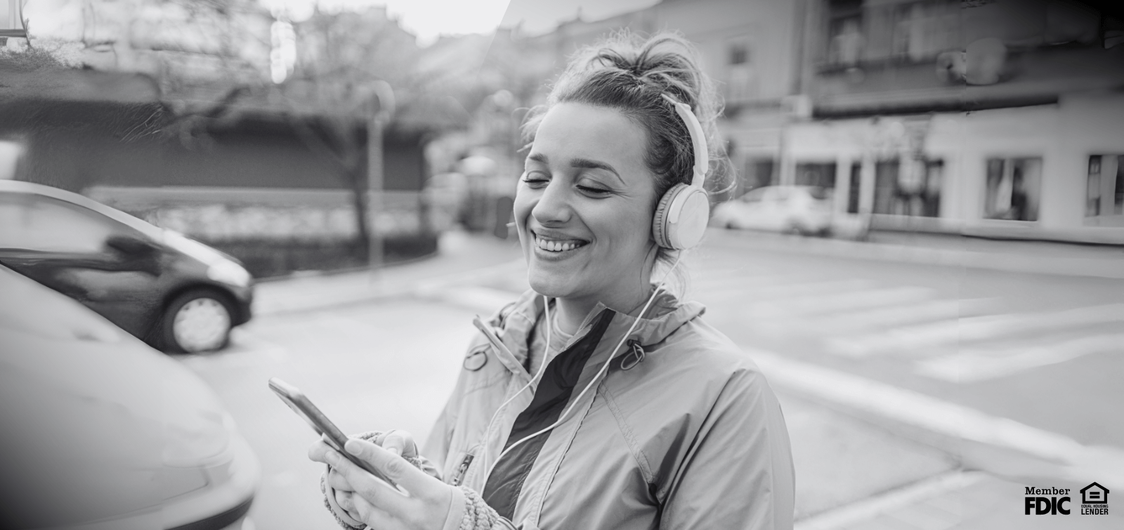 A young woman fills out a credit application on her phone while running errands. 
