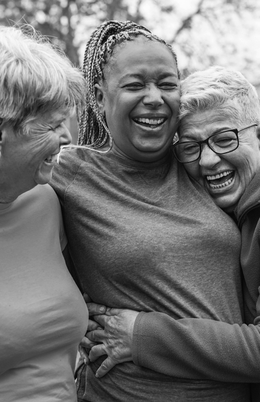 Mature group of women who are friends laughing together and hugging