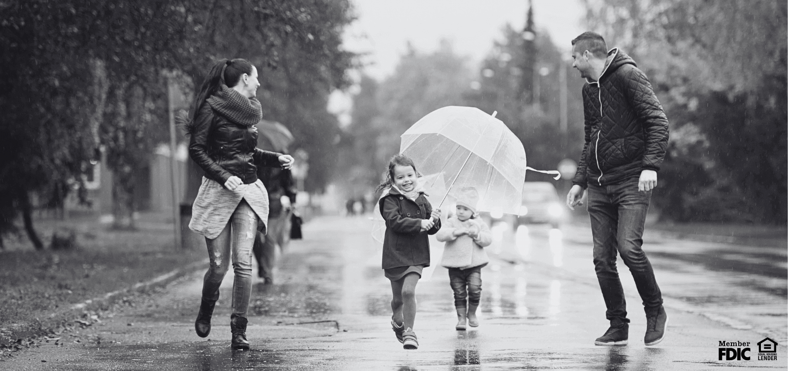 a family going for a walk in the rain with umbrellas